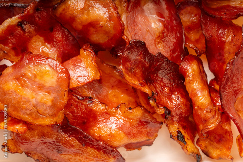 Foto Close up shot Crispy fried bacon texture, Freshly cooked and golden brown fried bacon on black dish