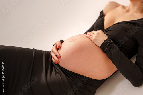 Pregnant woman shows baby bump while resting on floor