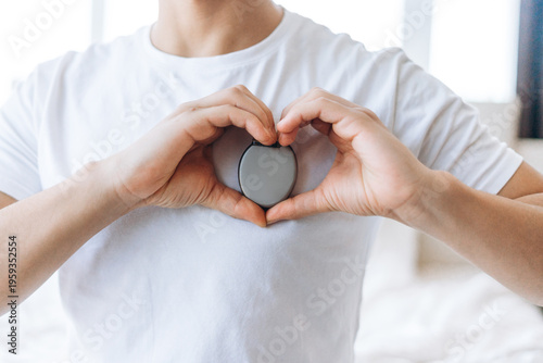 Tableau sur toile Closeup, young man holding and showing pacemaker, selective focus on hands