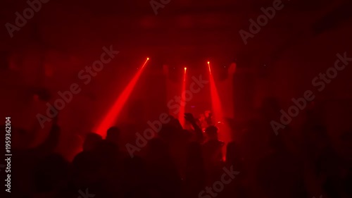 Crowd of Unrecognizable People Dancing at Underground Techno Rave Party with Bright Red Laser Beams and White Spotlights in Dark Smoky Nightclub Interior Intense Electronic Music Event Atmosphere