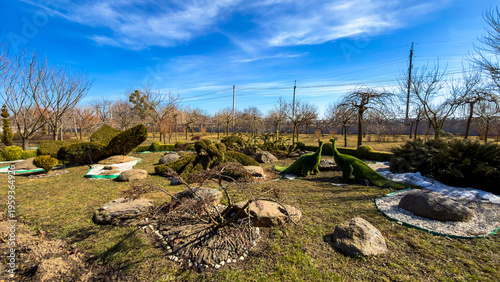 Dino-shaped bushes in spring. Bushes shaped like dinosaurs are in a garden.