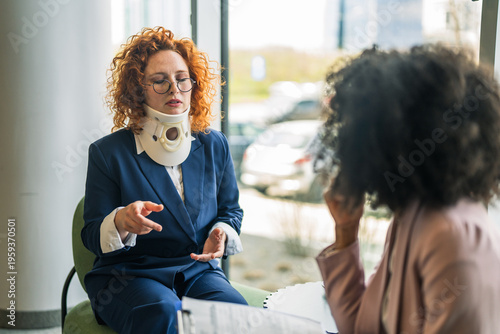 Photos Woman with neck brace discussing legal compensation with lawyer
