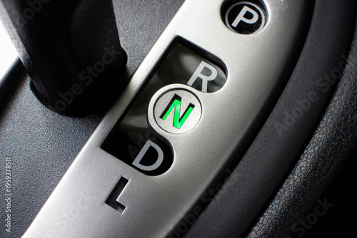 Automatic Gear Shifter, A close-up of a modern silver automatic transmission gear shifter showing P, R, N, D, and L, with the neutral N position illuminated green.