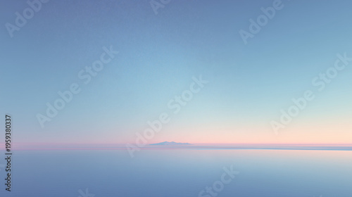 A serene landscape featuring a calm body of water reflecting a pastel sky at dawn. The horizon shows a distant mountain silhouette.