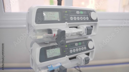 Close-up of a dual-stack syringe infusion pump system delivering medication in a bright, modern hospital or veterinary clinic setting.