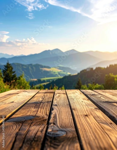 A wooden table overlooks a majestic mountain range bathed in golden sunlight.