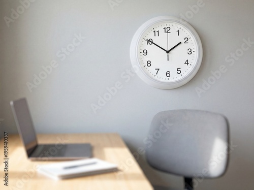 Modern office workspace with clock, laptop, and chair on wooden desk in minimalist gray room