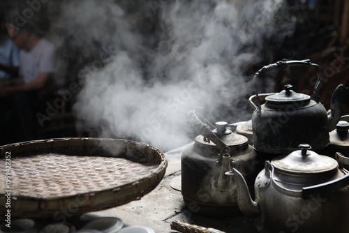 Fotografija Traditional Chinese teapots steaming with hot water vapor in a rustic tea house,