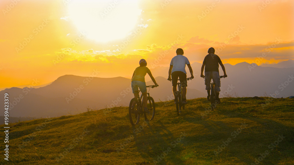 Fototapeta premium SUN FLARE Young cross country cyclists enjoying a relaxing ride on sunny evening
