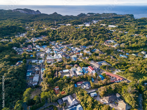 式根島の都市部。
青い海と緑の森が美しい、式根島の空中ドローン撮影。
東京都伊豆諸島式根島-2025

式根島は東京都心から南へ160km。
外周12kmの小さな有人島。
温かい黒潮が当たり水温と水質が高い。
また、リアス式の入り組んだ入り江が多く、海水浴や釣りが盛ん。
温泉島としても有名。海際に多くの無料露天風呂がある。
