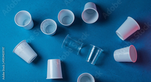 top view of white and plastic cups on blue background