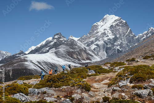 Group hikers with backpacks walking mountain trail during a hike of the Trekking on Trail to Everest Base Campduring, Nepal.
