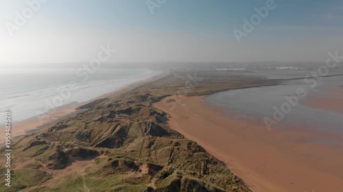 Drone glides smoothly over rugged coastal cliffs and sandy beaches at Tramore, revealing vast untouched beauty and inspiring deep awe and serenity.