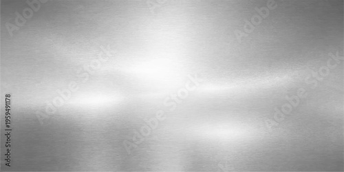 A polished silver stainless steel plate features a brushed metal texture with a shiny gray metallic surface and light reflection for a modern industrial background design