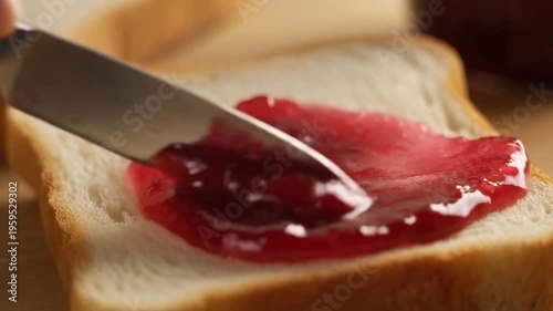 Red currant jam spread on bread served on a wooden board for a sweet breakfast or snack