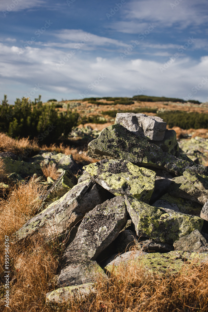 Fototapeta premium Rock cairn marking hiking path in Carpathian mountain landscape under dramatic sky