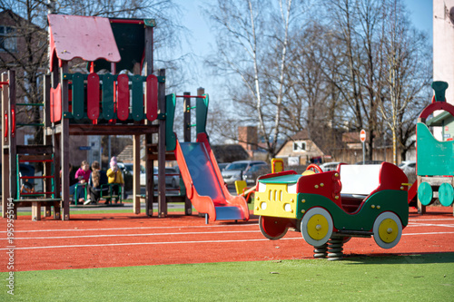 Children play on equipment in a park during a sunny day in the afternoon