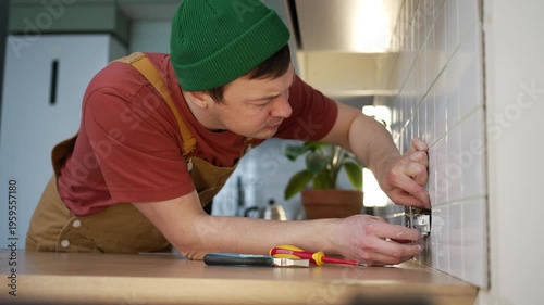 Inexperienced handyman struggling with a complex electrical socket installation, getting angry at the difficult task and eventually giving up, highlighting home improvement failure