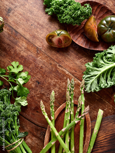 Healthy vegetables arranged on rustic wooden table for vegan meal preparation and presentation with various green options
