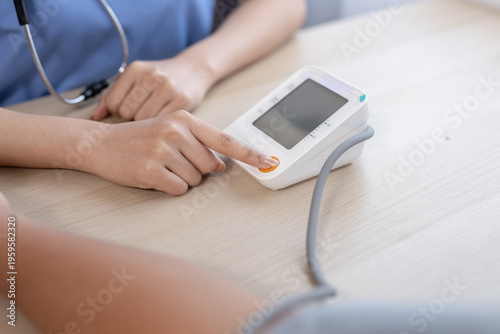 Konstfotografi Close-up of nurse pressing digital blood pressure monitor during health check