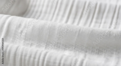 Soft focus shot of white pleated or seersucker fabric showing soft ripples and light shadows.