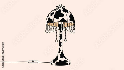 Decorative table lamp featuring a black and white cow print shade and base with elegant hanging crystal fringe.