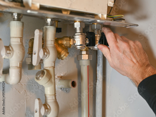 Hand Adjusting Plumbing Valve on Water Heater System