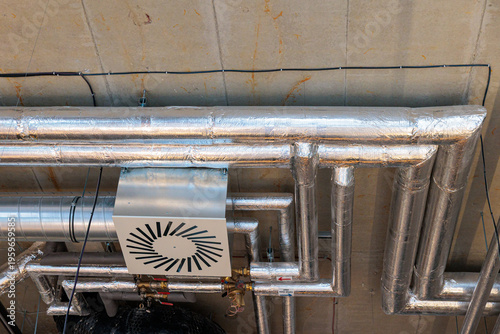 Tableau sur toile Insulated HVAC Ductwork and Piping on Industrial Concrete Ceiling in Commercial