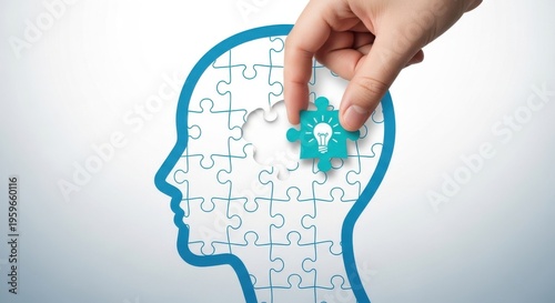 A hand placing a puzzle piece with a lightbulb into a jigsaw puzzle of a head