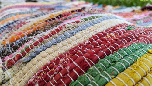 Close up of colorful woven rug texture on stone bench