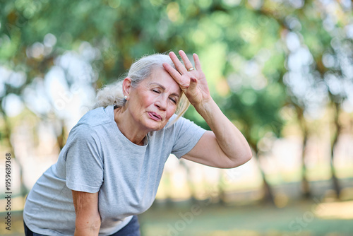 Billede på lærred Portrait of a senior elderly woman exercising in a park, tired mature female run