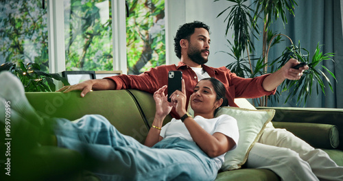 Картината върху платно Happy couple, relax and watching tv with phone on sofa for entertainment together in home