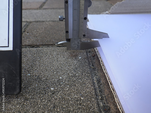 Photos Measuring the thickness of a polycarbonate sheet with a vernier caliper for mate