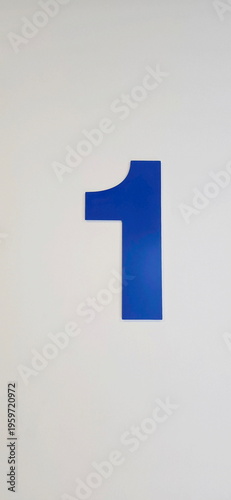 Free Download 1 is written in blue on a white wall. The large number on white background indicates the location, floor of parking garage, the position of pillar, Write the number 1 on cement wall. The big 1. 
 - GFXLoad