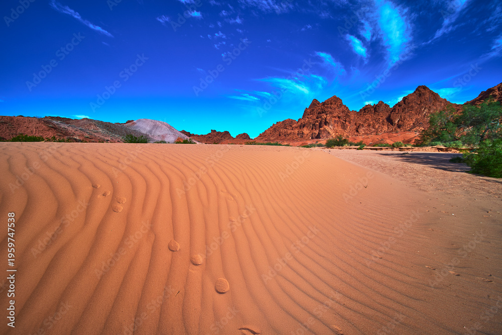 Fototapeta premium Sand Dune Patterns Red Rock Mountains and Dramatic Sky Nevada Desert Landscape