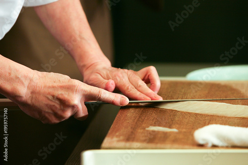 Foto Chef's hands precisely cutting food with a sharp knife on a wooden board