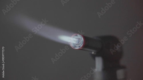 Close up flame of cooking gas blow torch over black background, side view. High quality FullHD footage