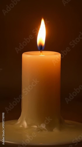 Glowing candle with warm flame on brown background