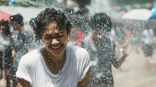 Woman laughing while being splashed with water during Songkran festival