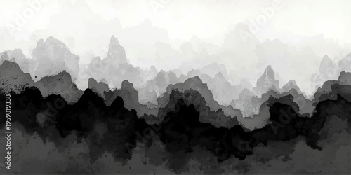 A serene morning panorama of the misty Alps peaks at sunrise, featuring a blue mountain landscape where fog and clouds drift over the forest valley and snowy silhouettes