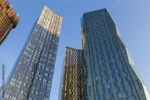 Foto A low-angle shot looking up at the glass facades of the Deansgate Square towers in Manchester UK at Sunrise