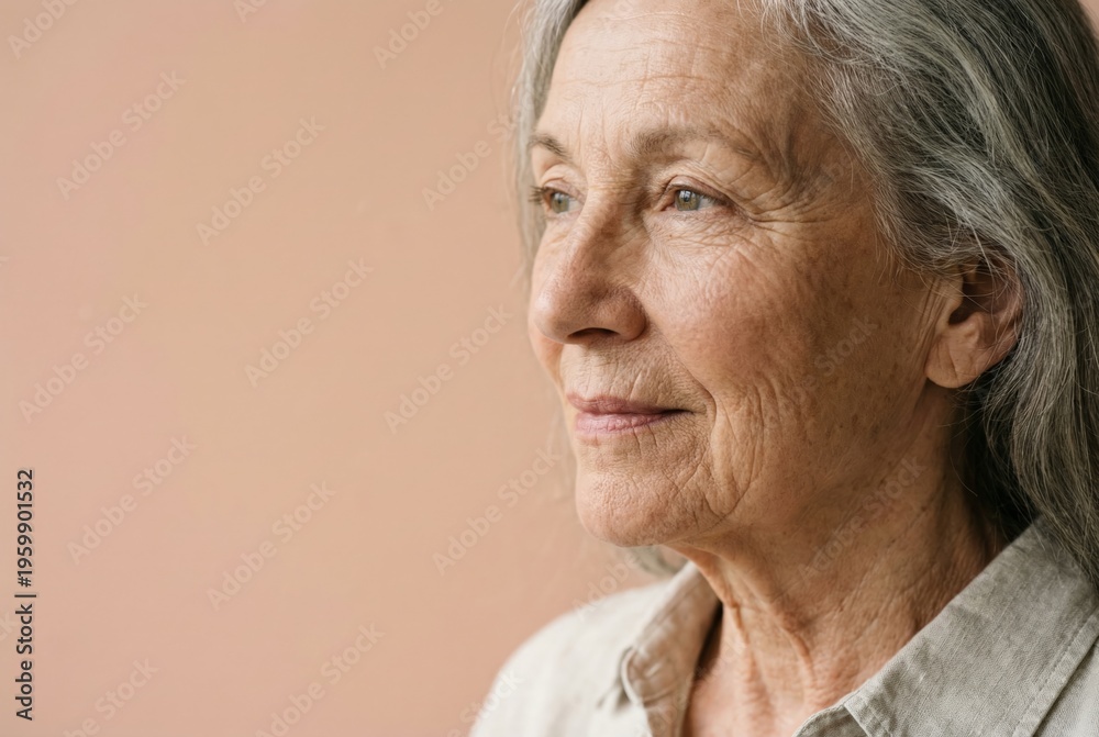 Obraz premium Senior woman with long grey hair and wrinkled skin facing right, embodying the beauty of aging and the experience of a mature individual looking towards the future