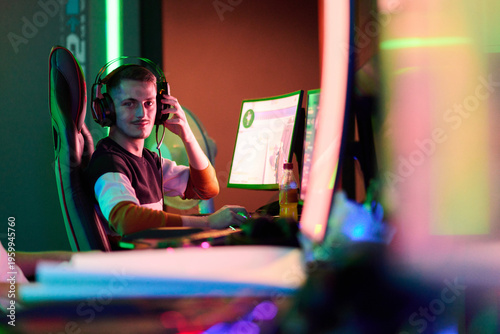 Competitive Gamer Streaming Online From Neon-Lit Gaming Room Wearing Headset At Dual Monitors