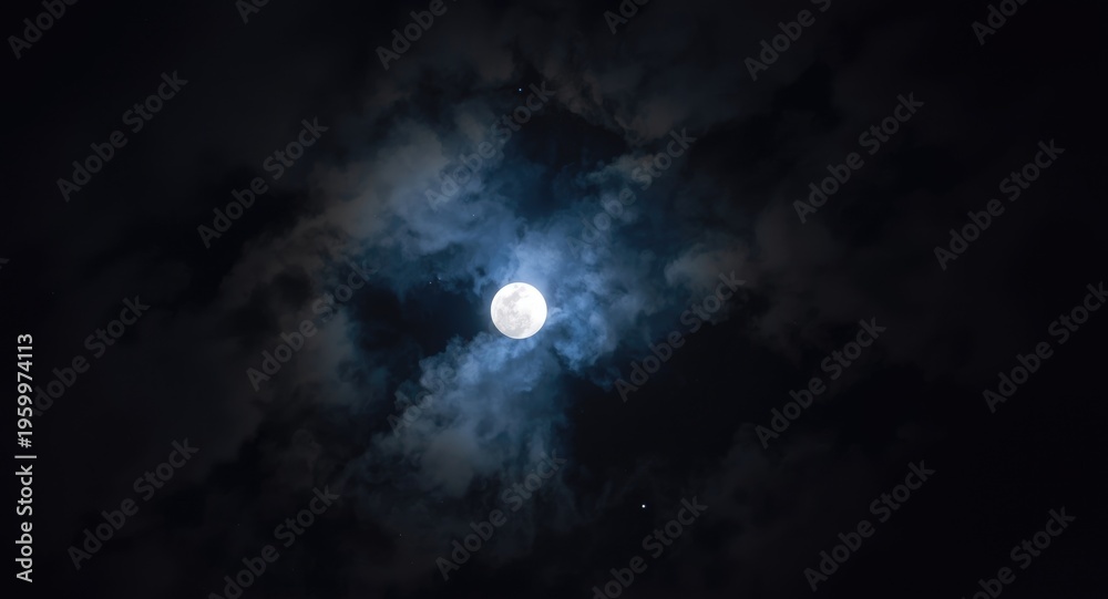 Fototapeta premium Mesmerizing full moonlight shining through night clouds in a celestial sky