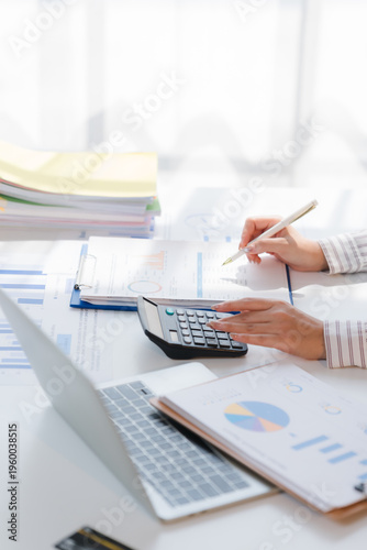 Business financing accounting banking concept. Business woman hand doing finances and calculate on desk about cost at home office. Woman working on desk with using calculator, finance accounting.