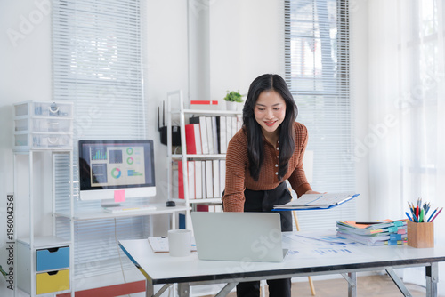 Shot of a asian young business Female working on laptop in her workstation.