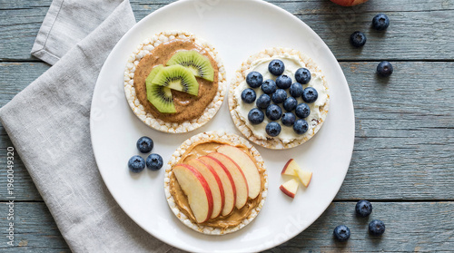 Wallpaper Mural Rice cakes topped with nut butter, fresh fruit, and berries on a white plate Torontodigital.ca