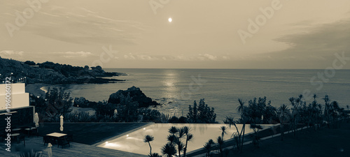 Εκτύπωση καμβά A stunning view : a vintage pool meeting the night ocean, with the moon glowing in the sky and its reflection shimmering on the water