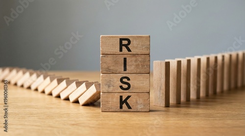 The domino effect of risk and potential failure. Wooden blocks spell the word RISK while others are set up to fall