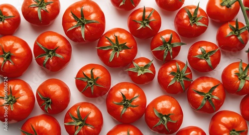 Overhead view of ripe tomatoes arranged on a clean white surface